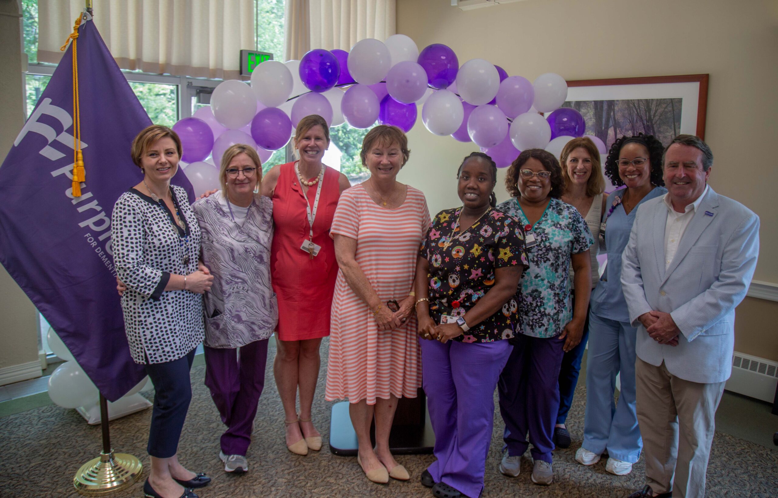 Christopher Carter, Ann Pavano, and the staff of McLean Life Plan Community pose for the community's Purple Flag reaccreditation.